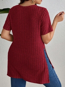 Detail shot of elegant red ribbed knit t-shirt featuring a stylish side slit design