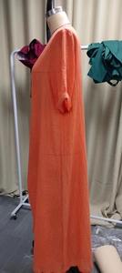 Détail d'une robe longue orange en coton et lin avec tissu texturé et coupe ample
