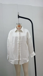 Detail shot of solid white long sleeve blouse with lapel collar and button closure