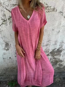 Détail de robe longue rose en coton et lin montrant la texture du tissu et le col en V