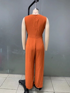 Rear view of orange sleeveless wide leg jumpsuit with back zipper on mannequin