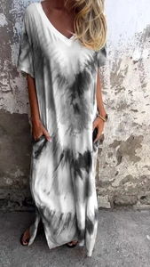 Dettaglio dell'abito lungo tie-dye con scollo a V, maniche corte e spacchi laterali estivi
