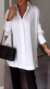 Detail of white oversized long sleeve shirt featuring a turn-down collar and hidden placket
