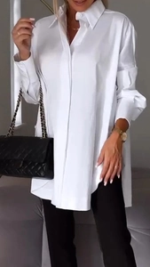 Detail of white oversized button-down shirt featuring classic collar and smooth fabric
