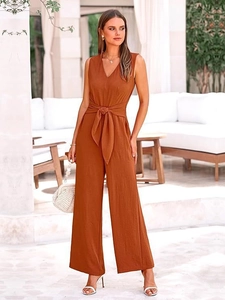 Detail of elegant rust V-neck sleeveless jumpsuit featuring a waist tie and wide-leg cut