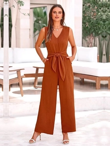 Detail of elegant caramel V-neck sleeveless jumpsuit with waist belt and wide leg cut