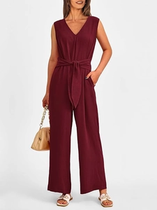 Close-up of wine red V-neck jumpsuit featuring a tied waist belt and wide leg texture