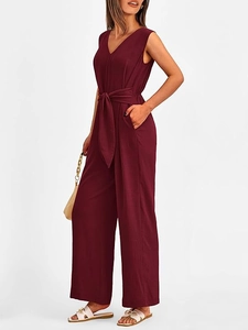 Detail of burgundy V-neck sleeveless jumpsuit showing waist tie and wide-leg design