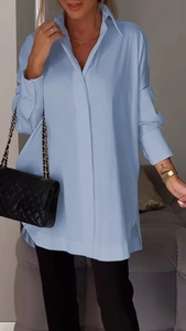 Detail of light blue oversized shirt showing collar, button placket and sleeve cuffs