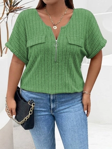 Detail of green ribbed V-neck top featuring silver zipper and decorative pocket flaps