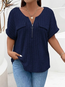Close-up of navy blue V-neck ribbed top with metal zipper detail and decorative pockets