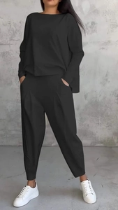 Dettaglio di un completo casual nero con top girocollo e pantaloni stile harem a pieghe