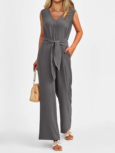 Macro detail of charcoal grey V-neck jumpsuit showing fabric texture and belted waistline