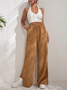 Detail of high waisted brown corduroy trousers featuring stylish side slit hems for women