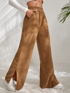 Detail of high waisted corduroy pants showing the side slit hem and textured fabric