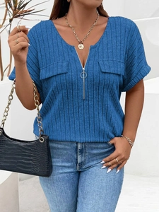 Detail of navy blue V-neck top showing ribbed texture and silver zipper with ring puller