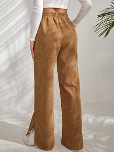 Macro detail of high waist brown corduroy trousers showing elastic waistband and texture