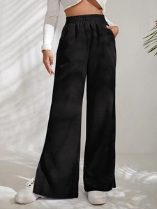 Detail shot of black corduroy trousers featuring a high-waisted elastic waistband design