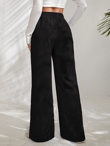 Detail of high waist elastic waistband on black corduroy wide leg trousers for women