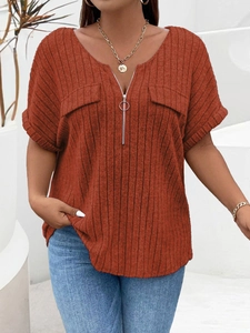 Detail of ribbed knit texture on dark orange V-neck shirt with a metal zipper