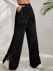 Detail of high waist corduroy pants with elastic waistband and side slit hem design