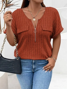 Detail of V-neck ribbed knit top featuring a silver zipper and faux flap pockets