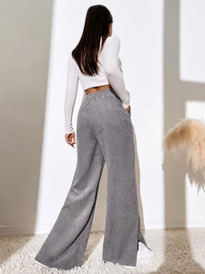Detail of high waisted grey corduroy trousers showing soft texture and side split hem