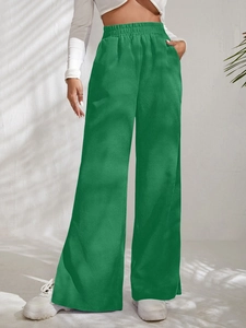 Detail shot of green corduroy high waist trousers featuring side pockets and split hem