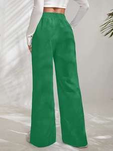 Detail of high waist elastic waistband on green corduroy trousers for women