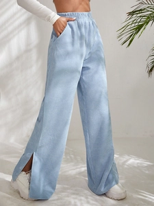 Detail of high waist corduroy trousers in light blue with side slit and elastic waistband