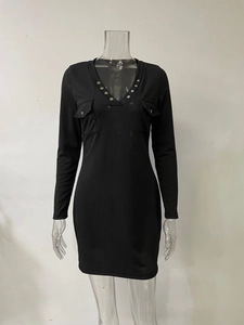 Détail du col en V avec clous métalliques argentés sur robe noire en maille côtelée