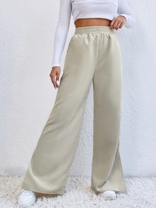 Detail of high waist corduroy wide leg trousers with elastic waistband and ribbed texture