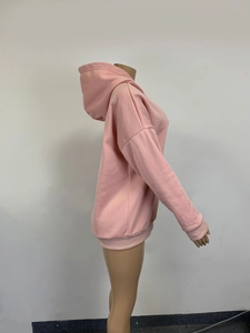 Side view of pink drawstring hoodie featuring ribbed cuffs and soft cotton blend fabric