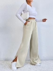 Detailed view of beige corduroy wide-leg trousers featuring a stylish side slit hem design