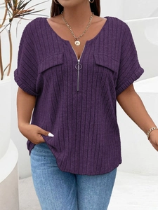 Detail of purple ribbed V-neck top featuring a round zipper pull and decorative pockets