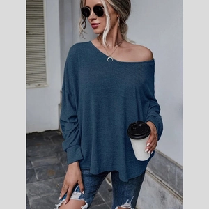 Détail du haut en tricot bleu foncé à épaules dénudées avec coupe ample et poignets
