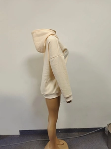 Side view of beige oversized hoodie showing loose fit and soft cotton blend fabric