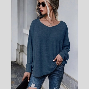 Détail d'un haut en maille bleu-gris à manches longues et col en V avec coupe ample