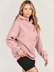 Detail of loose-fit dusty rose hoodie paired with black ribbed cycling shorts