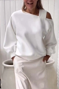 Detail shot of white off-shoulder sweatshirt with asymmetric neckline and ribbed cuffs