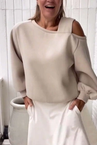Detail of asymmetric cold-shoulder neckline on a beige loose-fit long sleeve sweatshirt