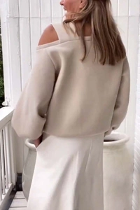 Detail of off-shoulder cream sweatshirt with puff sleeves and minimalist outdoor styling