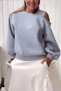 Detail showing the gray cold shoulder cutout and knit texture of this casual sweatshirt