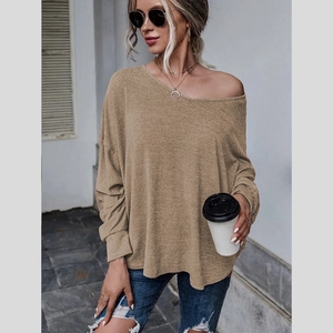 Détail d'un haut en tricot kaki ample avec encolure dénudée et style urbain décontracté