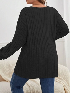 Detailansicht der schwarzen Strickjacke mit Rippenmuster, weicher Textur und überschnittenen Schultern