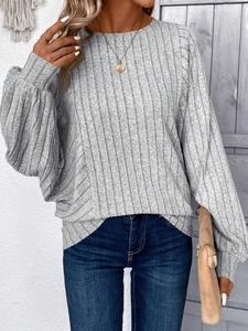 Detailed texture of grey ribbed knit sweater with elegant lantern sleeve cuffs