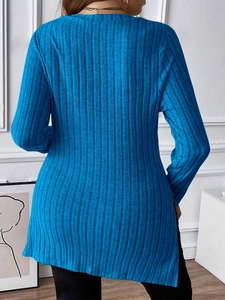Detail view of the ribbed knit texture and back hem design of this blue long sleeve top