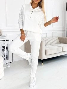 Close-up of white two-piece lounge set featuring a buttoned Henley neck and ribbed cuffs