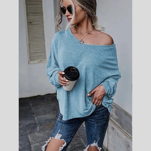 Détail d'un haut en tricot bleu clair à épaules dénudées avec coupe ample et tissu texturé