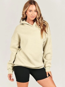 Detail of loose-fit sage green hoodie paired with black ribbed cycling shorts on a model